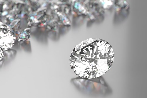 Diamond with many facets with blurred diamonds in the background